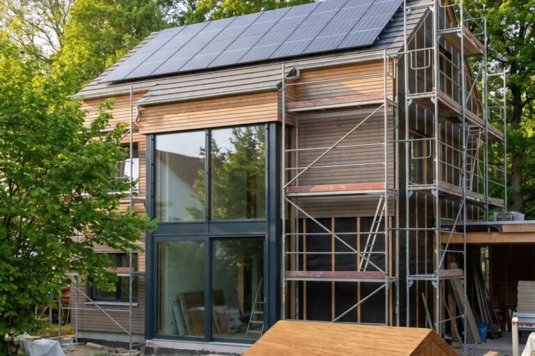 Einfamilienhaus mit Gerüst und Solaranlage während der energetischen Sanierung