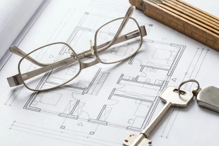 Grundriss mit Brille, Zollstock und Hausschlüssel